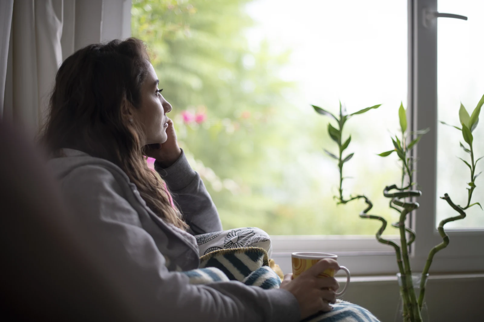 A person pausing beside a window.