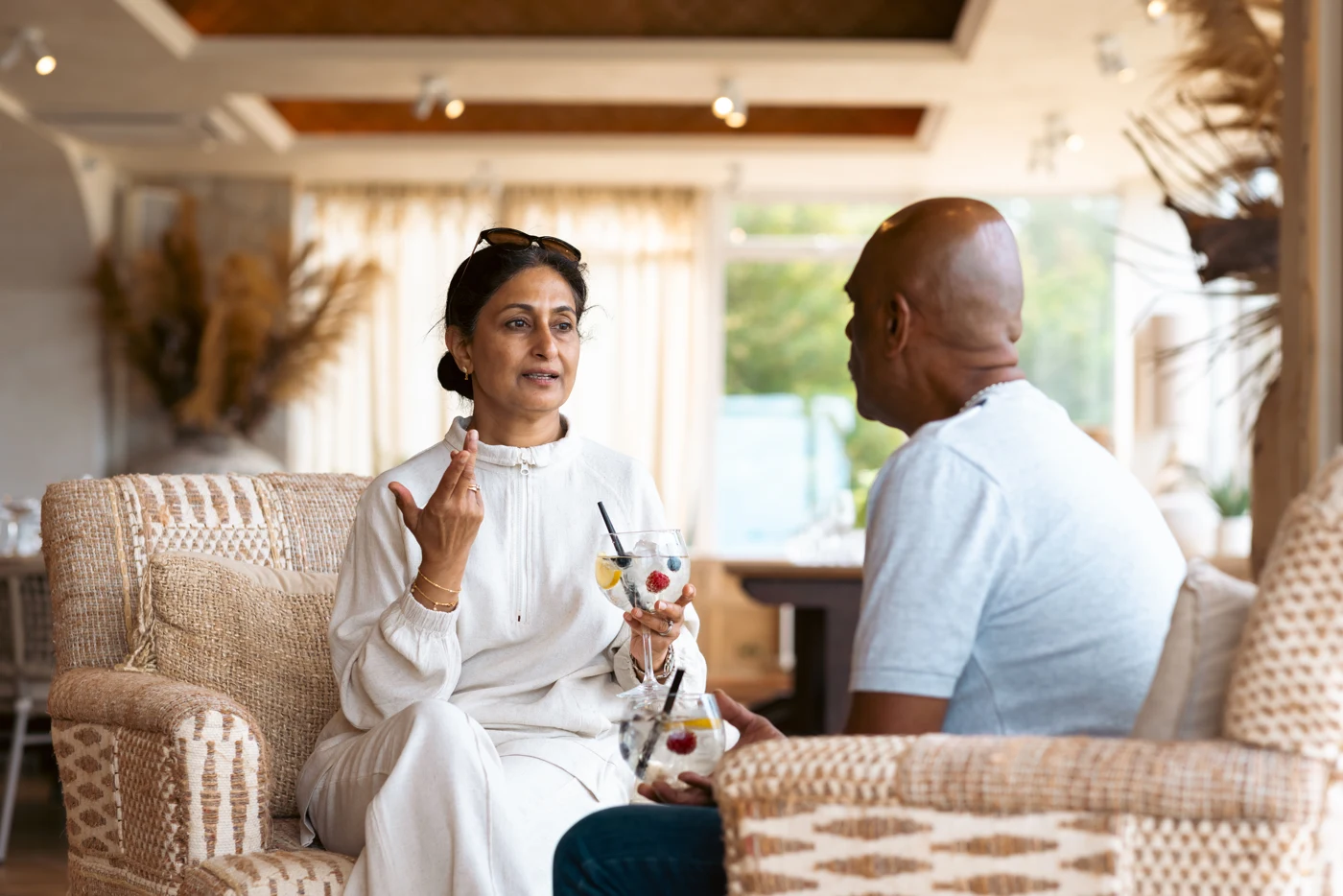 Two people seated facing each other in conversation.